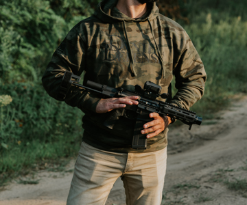 Green camouflage hoodie with Daniel Defense written in big black letters on the top-center