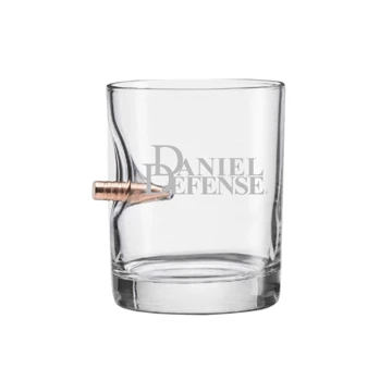 A transparent glass with Daniel Defense written in silver,  and a bullet going through the left side