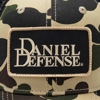 Image of a camo hat with tan and black Daniel Defense patch