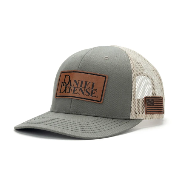 Grey trucker hat with a mesh back and a leather patch with the Daniel Defense logo