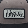 Grey trucker hat with black mesh back with a Daniel Defense patch on the front