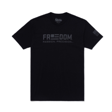 A black t-shirt with the words "FREEDOM. PASSION. PRECISION" printed in large, bold letters across the chest. An American flag is printed on the left shoulder.