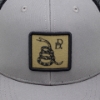 Grey and black mesh trucker hat with snake design and Daniel Defense logo on patch